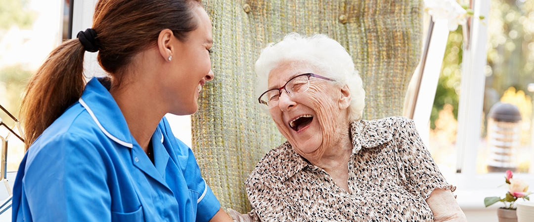 Nurse and resident sharing a big laugh together.